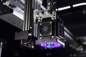Massivit 3D printing machine with a purple UV curing light